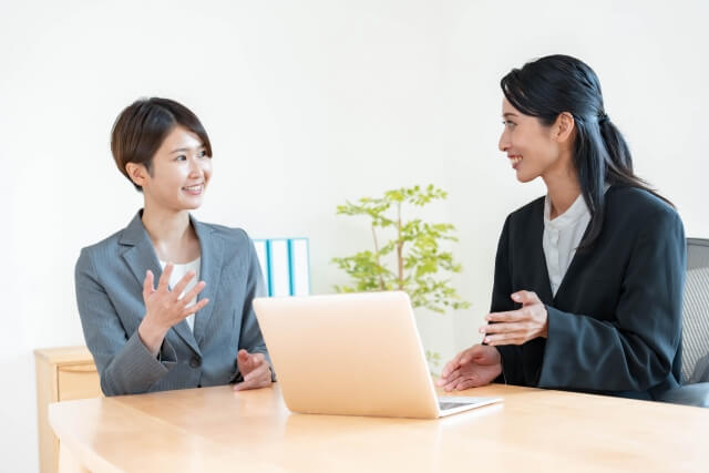 会議中に話し合う二人の女性
